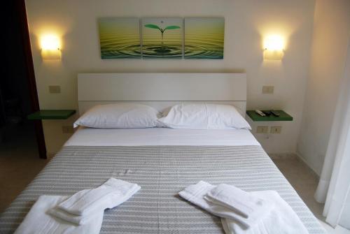 sypialnia z łóżkiem z dwoma białymi ręcznikami w obiekcie Albergo Belvedere w mieście Ventotene