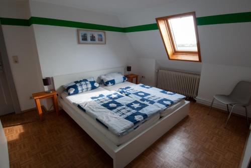 a bedroom with a bed with blue and white sheets at Haus Neu-Möhlhorst in Fleckeby