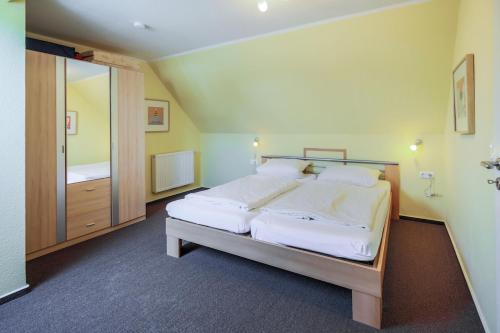 SahrensdorfにあるFerienhof Büdlfarm - Sperlings Lustのベッドルーム(白いシーツを使用した大型ベッド1台付)
