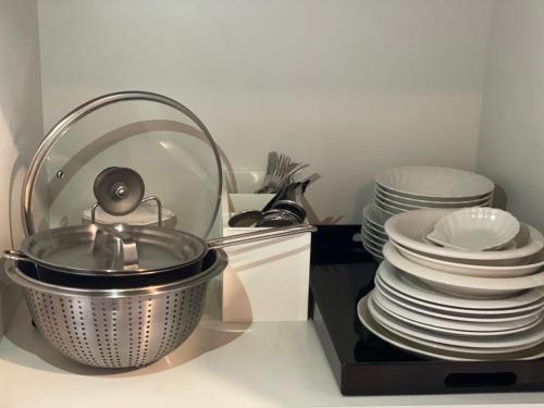 a kitchen with plates and a pot and a stack of dishes at 嬉々の屋KIKI Chalet in Hakuba