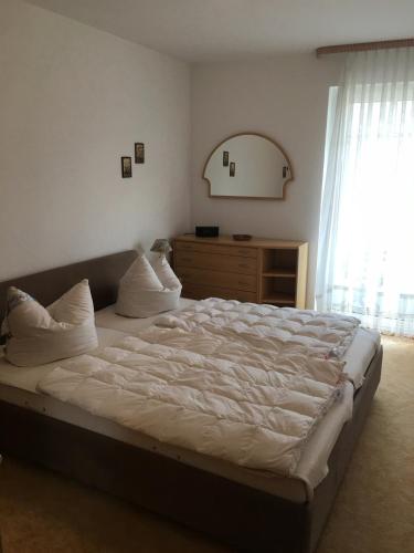 a bedroom with a large bed with a dresser and a window at Meerlust App 6 in Zingst