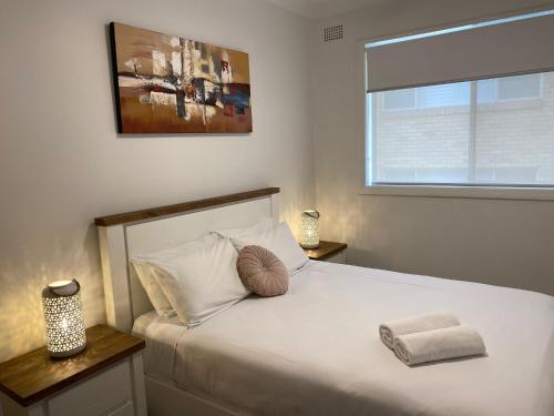 Blue Pacific Apartment 8 في ذا إينترانس: غرفة نوم مع سرير أبيض كبير مع نافذة
