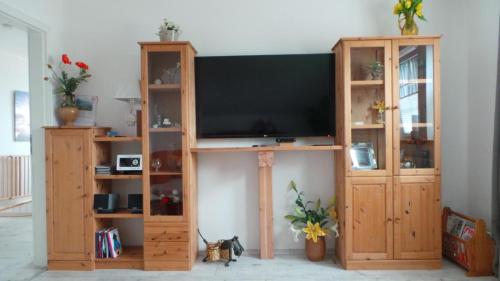 a large wooden entertainment center with a flat screen tv at Ferienwohnung Ihle in Heiligenhafen