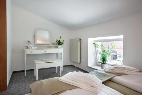 a white bedroom with a sink and a mirror at Knusthof - Wohnung 2 in Strukkamp auf Fehmarn