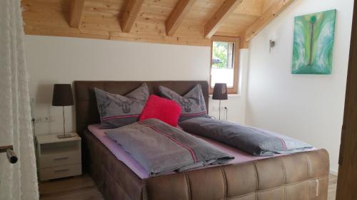 a bed with pillows on a couch in a room at Ferienhaus Casa Rosa - LienzOsttirol in Leisach