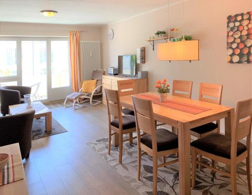 ein Wohnzimmer mit einem Holztisch und Stühlen in der Unterkunft Komfort FeWo mit Meerblick in Kühlungsborn