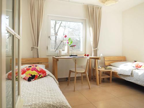 a bedroom with two beds and a table and a window at Am Paalen 2 Whg 1 in Zingst