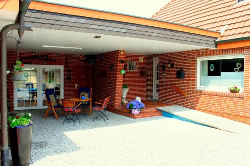 a brick house with a patio with a table and chairs at Ferienwohnung Meyer in Surwold