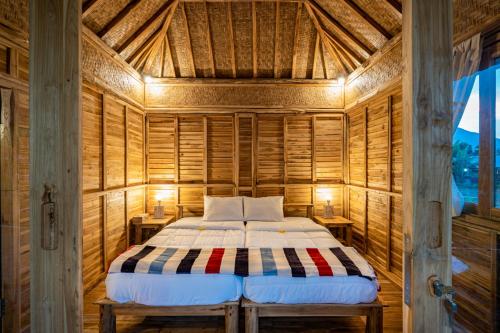 a bedroom with a bed in a wooden room at Pondok Manoka in Kintamani