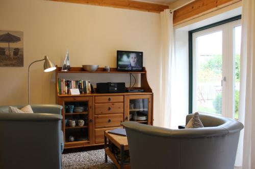 a living room with two chairs and a tv at "Rosenkate 1" in Riepsdorf