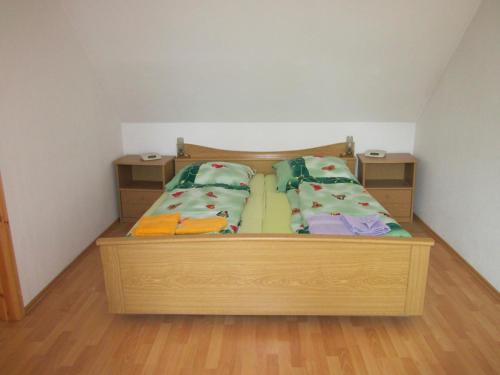 a bedroom with a wooden bed with pillows on it at Blick zur "Orther Bucht" in Teschendorf