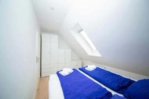 two beds in a white room with blue sheets at Schleitraum Appartement in Karschau