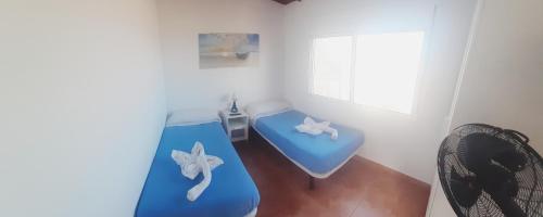 Habitación con cama azul y ventana en Puestita de Sol en Frontera