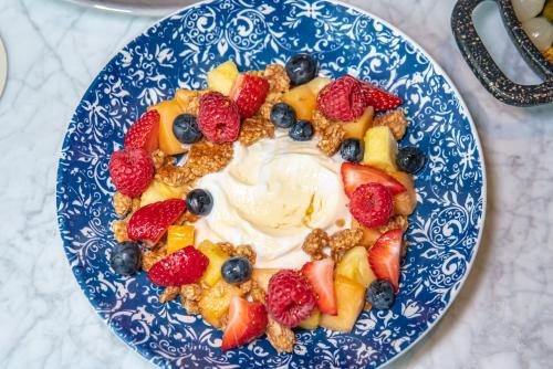 a blue and white plate of fruit and whipped cream at Kimpton Banneker Hotel, an IHG Hotel in Washington, D.C.