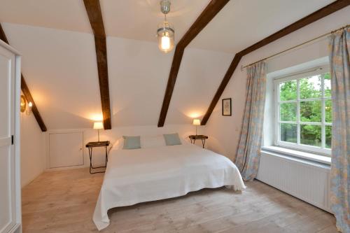 - une chambre avec un lit blanc et une grande fenêtre dans l'établissement Altes Komödienhaus - Schloss Gelting, à Gelting