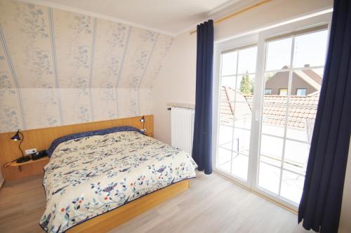 a bedroom with a bed and a large window at Flieder in Dahme