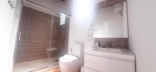 a bathroom with a toilet and a shower and a sink at Puestita de Sol in Frontera