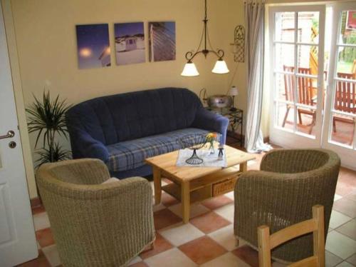 a living room with a blue couch and two chairs at Buernstrat in Boldixum