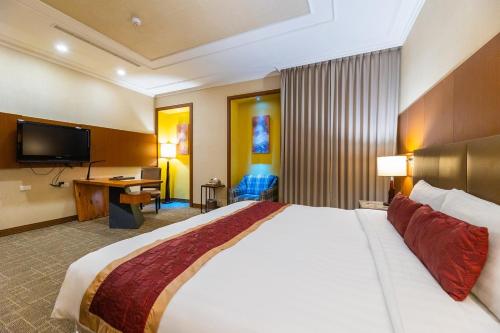 a hotel room with a large bed and a television at Golden Tulip - Aesthetics in Zhunan