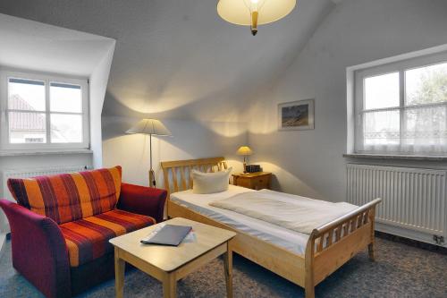 a bedroom with a bed and a couch and a chair at Altes Wasserwerk, App 8 in Zingst
