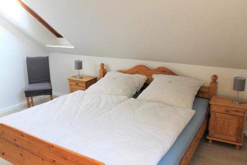 sypialnia z 2 łóżkami i krzesłem w obiekcie "Pappelhof - Whg 4" w mieście Grömitz