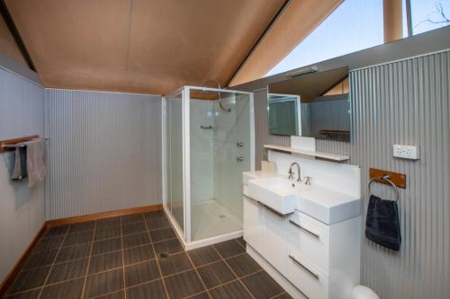 un bagno con doccia in vetro e lavandino di Kings Creek Station a Kings Canyon