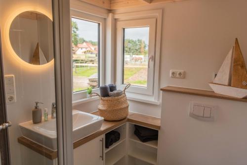 a bathroom with a sink and a window at Huxfeld-Hof - Tiny-House MOORitz in Grasberg