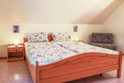 um quarto com uma grande cama de madeira e uma cadeira em Landglück em Klausdorf