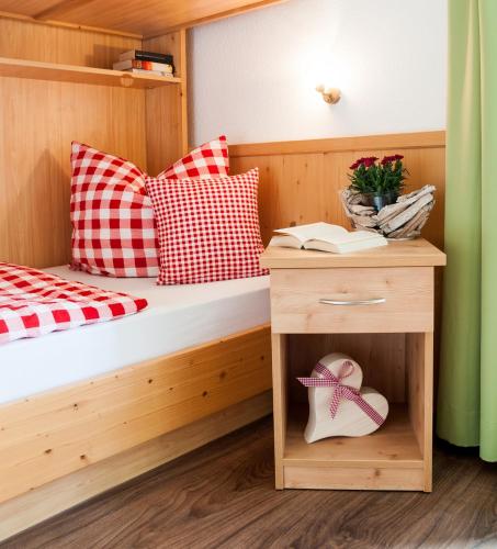 - une chambre avec un lit et une table de chevet avec un livre dans l'établissement Riederstein, à Bad Wiessee