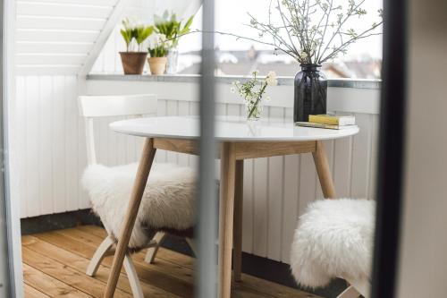 a dining room table with two chairs and a vase with flowers at Whg 16 - Sol in Zingst