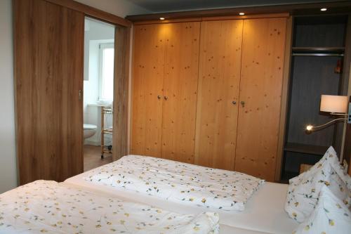 - 2 lits dans une chambre avec des placards en bois dans l'établissement Riederstein, à Bad Wiessee