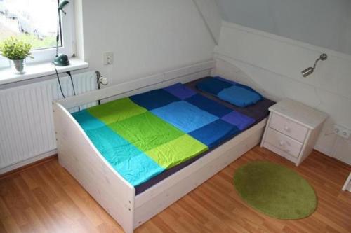 a bedroom with a bed with a colorful blanket at Ferienhaus 3370 in Tossens in Butjadingen OT Tossens