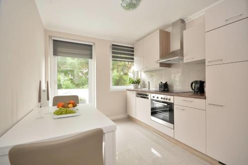 a kitchen with white cabinets and a bowl of fruit on a counter at Business Apartments Bremen Typ 3 in Bremen