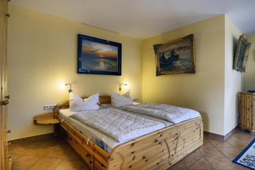 ツィングストにあるKranichguck, App 2のベッドルーム1室(木製ベッド1台、壁にランプ2つ付)