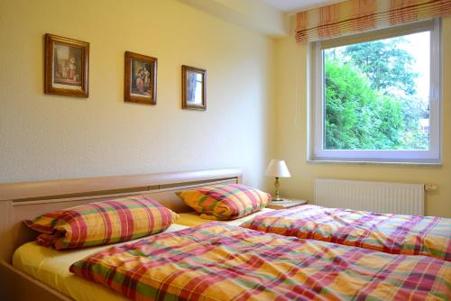 2 Betten in einem Zimmer mit Fenster in der Unterkunft Haus am Grömitzer Deich - Whg 4 in Grömitz