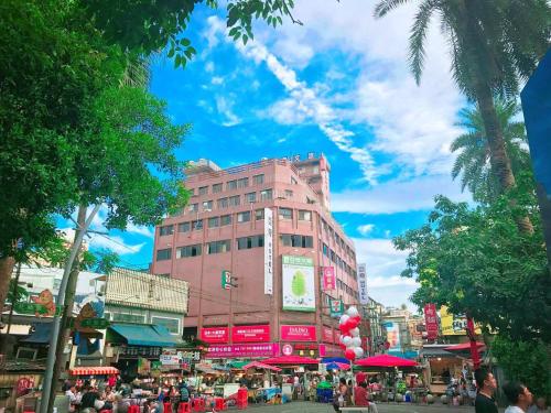 a pink building on a street with a crowd of people at 樂亞亞奇文旅 in Luodong