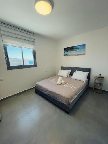 a bedroom with a bed in a room with two windows at דירת נופש ׳חושן׳ in Eilat