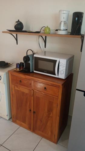 a microwave sitting on top of a wooden cabinet at Manava Tahara'a Home Stay in Mahina