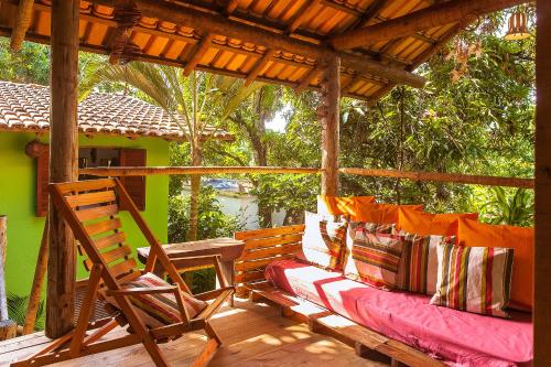 a porch with a bench and a pergola at Vila Auê Suites in Caraíva