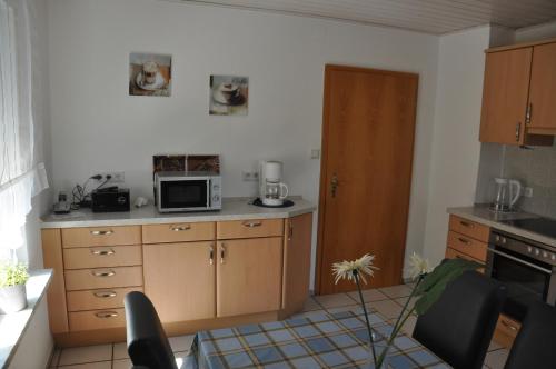 uma cozinha com armários de madeira e um micro-ondas em Ferienhaus "Antonia" - a47030 em Witzenhausen