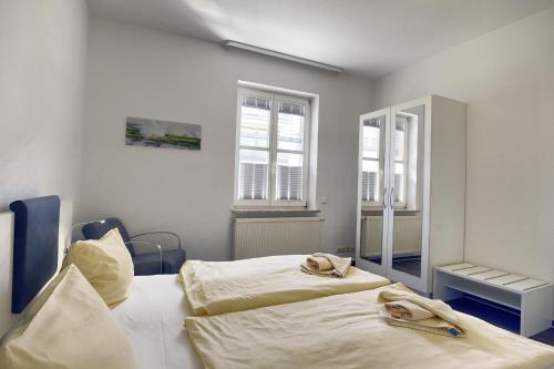 a bedroom with two beds and two windows at Altes Wasserwerk, FW 9 in Zingst