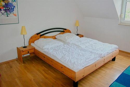 ツィングストにあるIlling, Wolfgang FW 8のウッドフロアのベッドルーム1室(木製ベッド1台、ランプ2つ付)