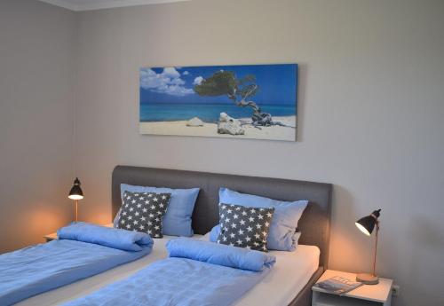 a bedroom with two beds and a picture of the beach at Fehmarnstrand 77 Whg 2 in Staberdorf