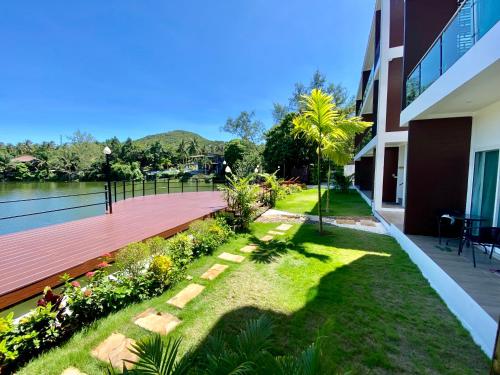 a garden with a wooden walkway next to a building at Pure Laguna Residence by Nice Sea Resort in Srithanu