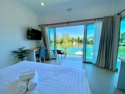 a bedroom with a bed with a view of the water at Pure Laguna Residence by Nice Sea Resort in Srithanu
