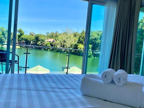 a bedroom with a bed with a view of the water at Pure Laguna Residence by Nice Sea Resort in Srithanu