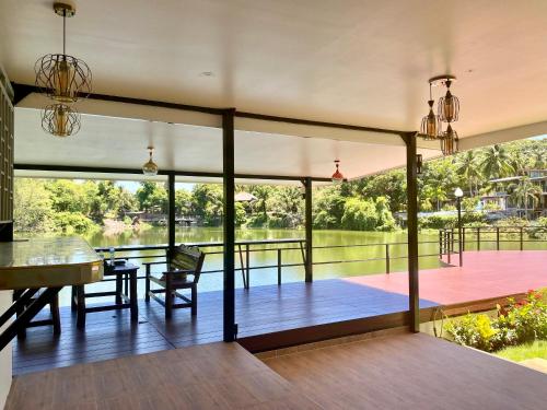 a screened in porch with a view of a lake at Pure Laguna Residence by Nice Sea Resort in Srithanu
