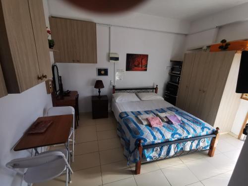 a bedroom with a bed and a table and a desk at Nicosia rooms Studios in Nicosia
