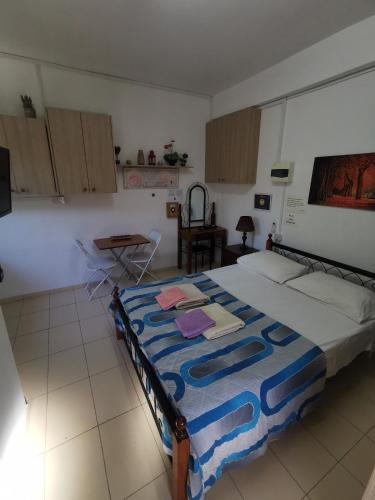 a bedroom with a bed with a blue blanket on it at Nicosia rooms Studios in Nicosia