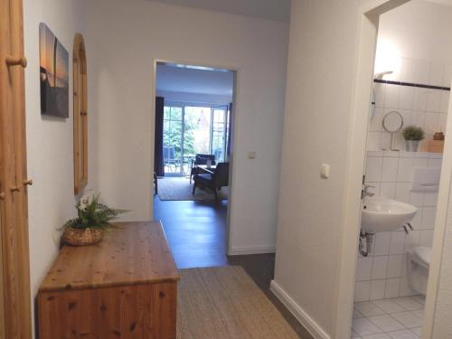 - un couloir avec une salle de bains pourvue d'un lavabo et de toilettes dans l'établissement Gästehaus Whg 1, à Prerow